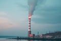 A lonely chimney with white smoke on the seashore. The concept of air pollution by industrial emissions into the atmosphere