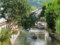 A Chinese old man rowing in a small boat along a wide water channel in Shaoxing China Royalty Free Stock Photo