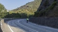 A lonely cyclist biking in an empty spanish road in the summer