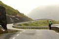 Lonely cyclist on a mountain road in a fog, Norway