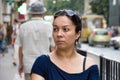 Lonely dark-haired woman looks thoughtfully and smiles in of the European street