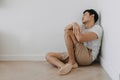 Lonely depressed man sit at the corner of the room. Royalty Free Stock Photo