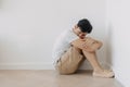Lonely depressed man sit at the corner of the room. Royalty Free Stock Photo