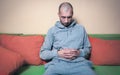 Lonely and depressed man feeling anxious and without reason for life sitting alone on his bed in his room dark image suicidal conc Royalty Free Stock Photo