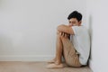 Lonely depressed man sit at the corner of the room. Royalty Free Stock Photo