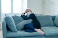 Depressed senior widow woman with protective mask alone at home feeling sad and missing family Royalty Free Stock Photo