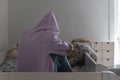 Lonely depressed teen girl wearing hood crying alone on bed Royalty Free Stock Photo