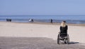 Lonely disabled young woman on beach. Sunny summer day