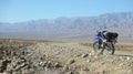 Lonely dual sport motorcycle on empty dirt road in Death Valley desert in United States