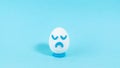 Lonely egg with a sad expression close up. The concept of a pessimistic outlook on life. Blue background