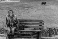 Lonely elderly woman on a bench in the park