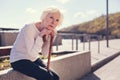 Lonely elderly woman resting after a long tiring walk