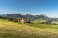 Lonely farm house and grazing cows in the Swiss Alps, view to the Alpstein mountains with Saentis, Switzerland Royalty Free Stock Photo