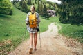 Lonely female with yellow backpack walking by mountain path with trekking poles to mount refuge hut in Slovakia, Mala Fatra region Royalty Free Stock Photo