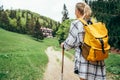 Lonely female with yellow backpack walking by mountain path with trekking poles to mount refuge hut in Slovakia, Mala Fatra region Royalty Free Stock Photo