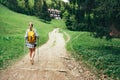 Lonely female with yellow backpack walking by mountain path with trekking poles to mount refuge hut in Slovakia, Mala Fatra region Royalty Free Stock Photo