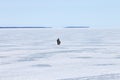 Lonely fisherman on the frozen lake fishing Ice hole Royalty Free Stock Photo