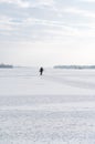 Lonely fisherman on ice. A lone fisherman in the middle of a large lake. Winter fishing Royalty Free Stock Photo