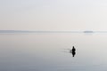 Lonely fisherman on the lake in the morning light