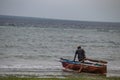 Lonely fisherman at the Mozambique sandy beach preparing boat to go for sailing and fishing Royalty Free Stock Photo