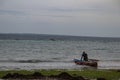 Lonely fisherman at the Mozambique sandy beach preparing boat to go for sailing and fishing Royalty Free Stock Photo