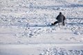 Fisherman sitting in the middle of the frozen lake waiting for the fish Royalty Free Stock Photo