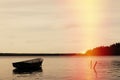 Lonely fishing boat docked in calm lake. wooden fishing boat in a still lake water. image of wooden fishing boat moored on the sho Royalty Free Stock Photo