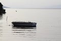 Lonely fishing boat docked in calm lake. wooden fishing boat in a still lake water. Royalty Free Stock Photo