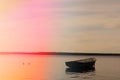 Lonely fishing boat docked in calm lake. wooden fishing boat in a still lake water. image of wooden fishing boat moored on the sho Royalty Free Stock Photo