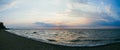 A lonely fishing boat in the sea against the background of the evening sunset sky. Large panorama Royalty Free Stock Photo