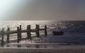 Lonely fishing boat and sea pier in dark ocean, sea. Royalty Free Stock Photo