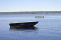 A lonely fishing boat sits anchored in frot of a dock. Royalty Free Stock Photo