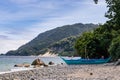 Lonely fishing boat stands on the beach with gorgeous mountain and blue sky!