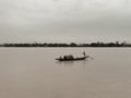 A lonely fishing boat with to sailors inside moving slowly along the river in Kolkuta