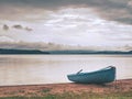 Lonely fishing vessel boat docked on beach at calm lake Royalty Free Stock Photo