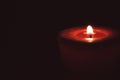 Lonely flame burning red candle in the dark Royalty Free Stock Photo