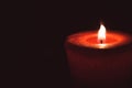 Lonely flame burning red candle in the dark Royalty Free Stock Photo