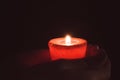 Lonely flame burning red candle in hand in the dark Royalty Free Stock Photo