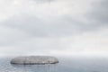 Lonely flat rock in ocean, cloudy sky