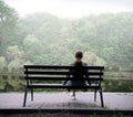 Lonely girl on a bench by the lake Royalty Free Stock Photo