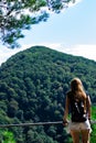 A lonely girl looks at the mountains on the other side. Low lying clouds and mountains