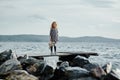 A lonely girl with a plush Bunny is standing on the pier and loo Royalty Free Stock Photo