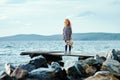 A lonely girl with a plush Bunny is standing on the pier and loo Royalty Free Stock Photo