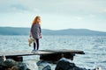 A lonely girl with a plush Bunny is standing on the pier and loo Royalty Free Stock Photo