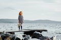 A lonely girl with a plush Bunny is standing on the pier and loo Royalty Free Stock Photo