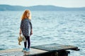 A lonely girl with a plush Bunny is standing on the pier and loo Royalty Free Stock Photo