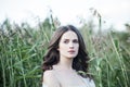 Lonely girl portrait. Spring woman walking alone outdoors on green grass background