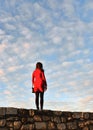 Lonely girl in red with cloudy blue sky and belgrade old fortress, serbia Royalty Free Stock Photo