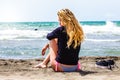 Lonely girl sitting at the beach with sea. Thoughtful and loving. Disappointment in love. Royalty Free Stock Photo