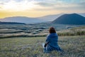 Lonely girl sitting next to Komezuka of Mount Aso Aso-san Royalty Free Stock Photo